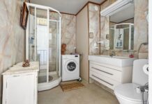 Jasna minimalistyczna łazienka z prysznicem umywalką i pralką