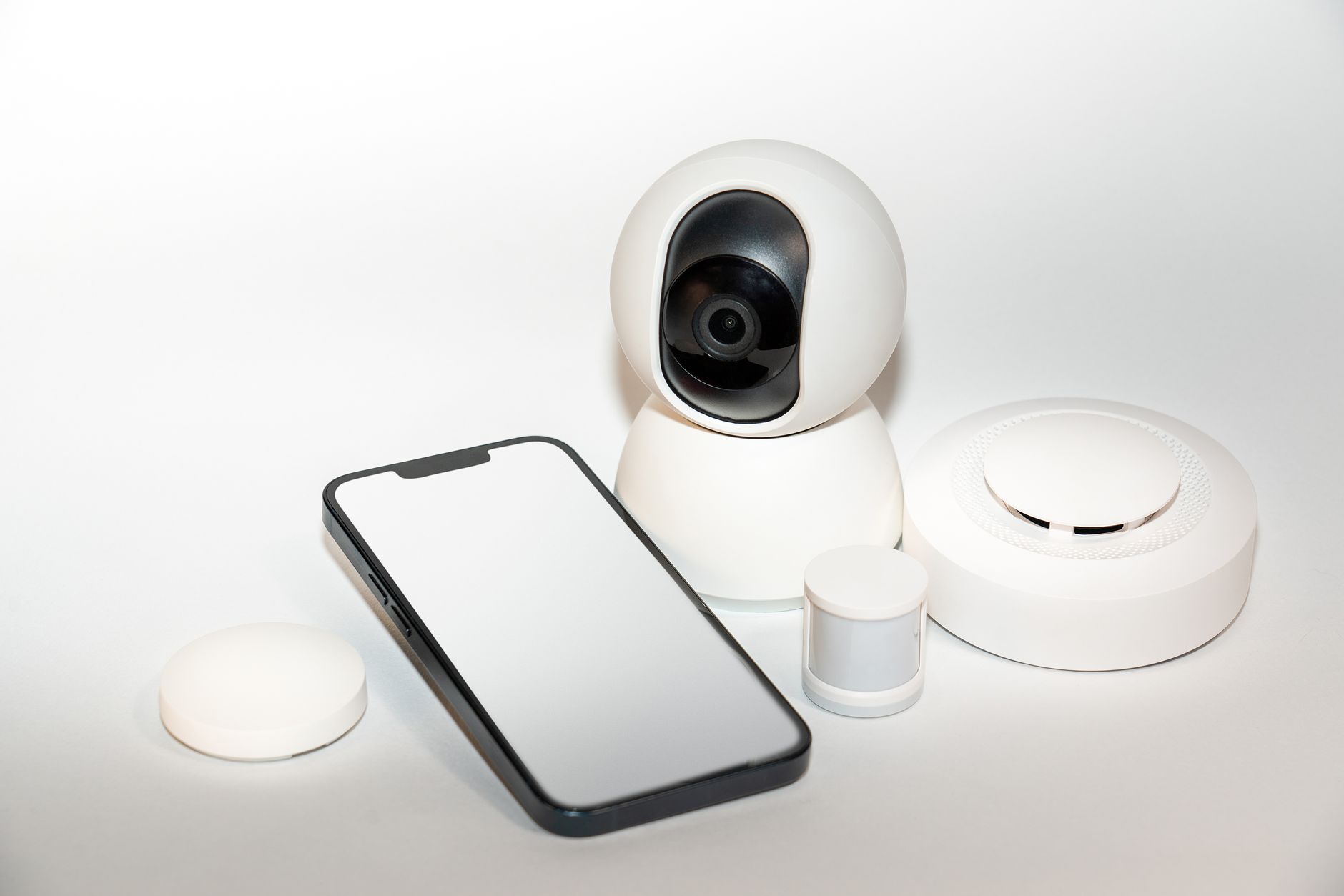 Zestaw urządzeń smart home i ekran smartfona z aplikacją sterującą